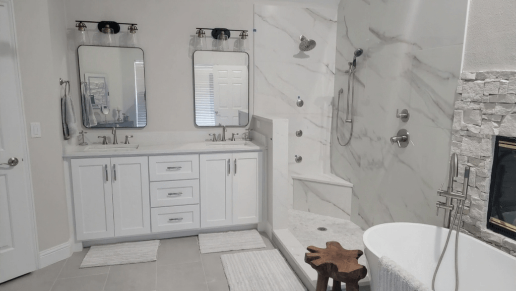 DFW's premier luxury bathroom remodeling— luxury master bath with double vanity, marble shower tile, freestanding soaking tub and stone fireplace by I Love My Bathroom