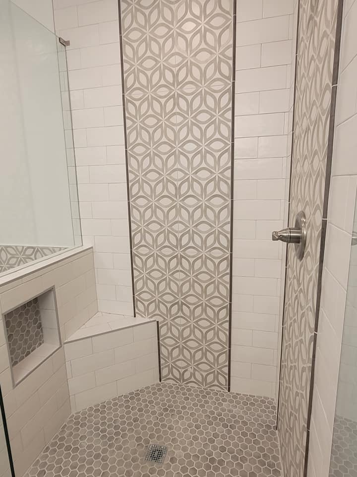 Master bath remodel Grapevine TX featuring geometric pattern accent tile shower walls white subway tile built-in niche hexagon mosaic floor and frameless glass door by I Love My Bathroom