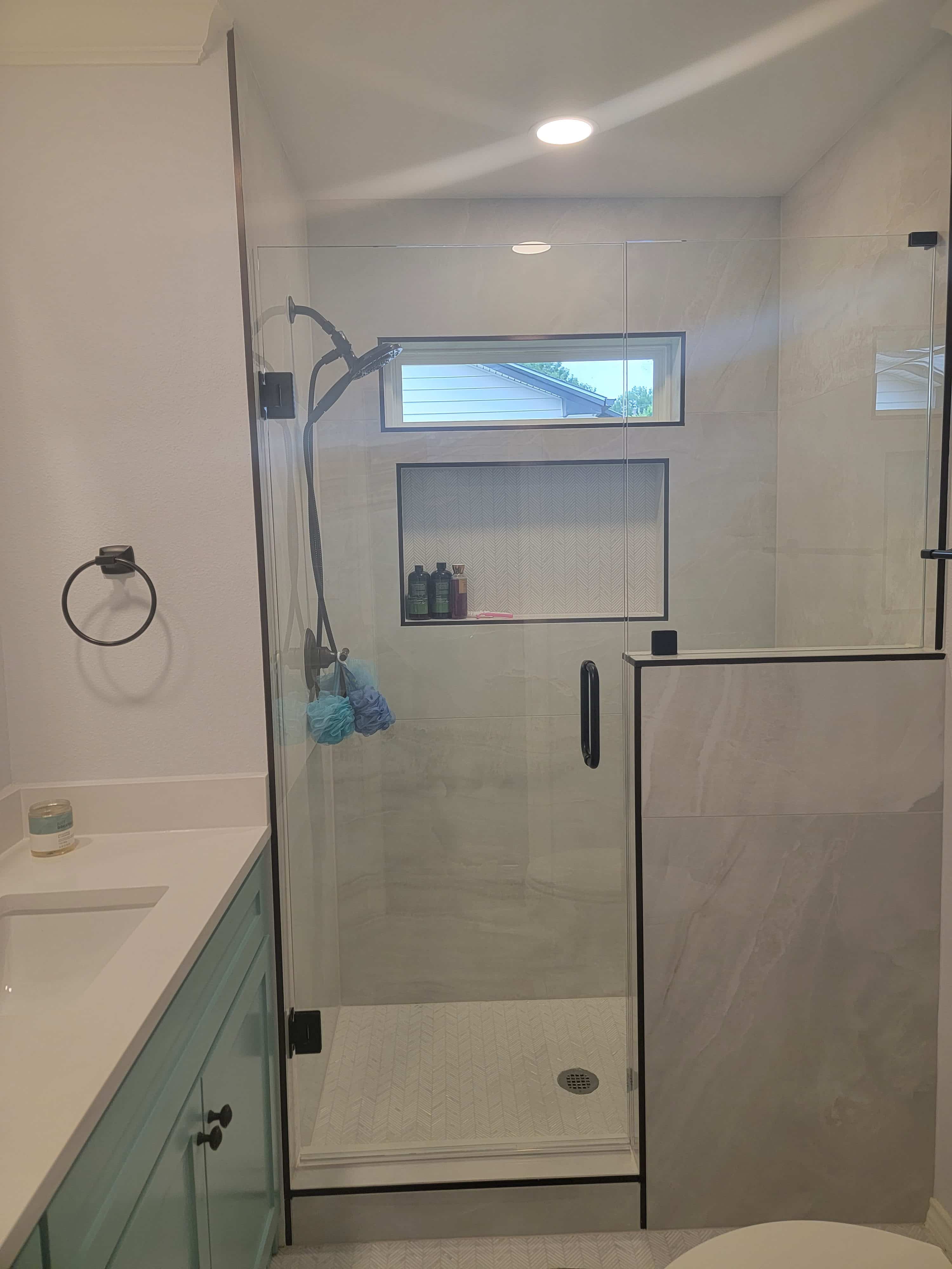 Modern bathroom design trends 2026 — sage teal vanity with white quartz countertop, frameless walk-in shower with large format tile, herringbone mosaic floor and matte black hardware by I Love My Bathroom Grapevine TX